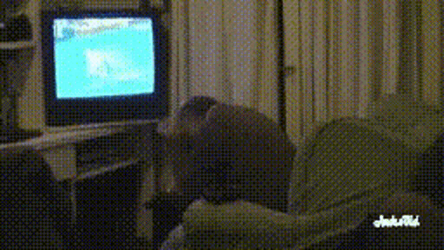 a person is sitting on a couch watching a television with the word junk on the bottom right