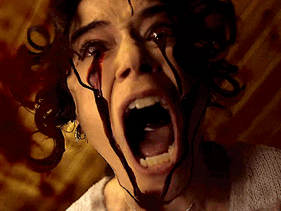 a close up of a woman 's face with blood coming out of it