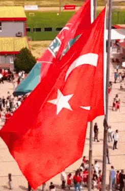 a large red flag with a white star on it is flying in the wind
