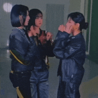 three women are posing for a picture with one wearing a jacket with the number 2 on it