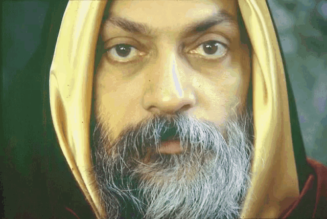 a man with a beard is wearing a yellow scarf around his neck
