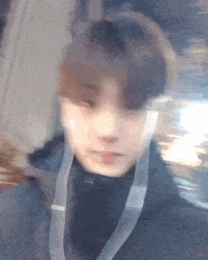a blurry picture of a young man wearing headphones and a black jacket .