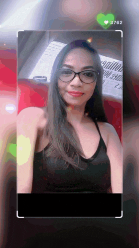 a woman wearing glasses and a black tank top has the number 3762 on her phone