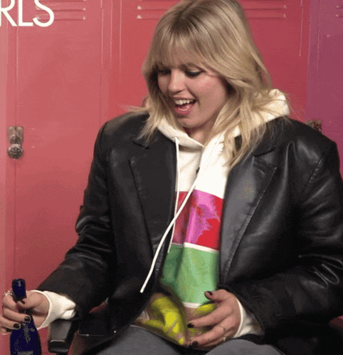 a woman sitting in front of a pink locker with the word rls on it
