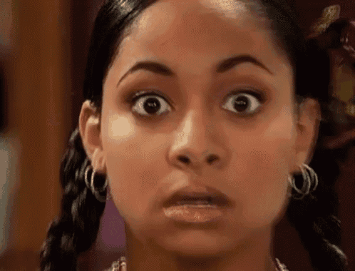 a close up of a woman making a surprised face with her eyes wide open .