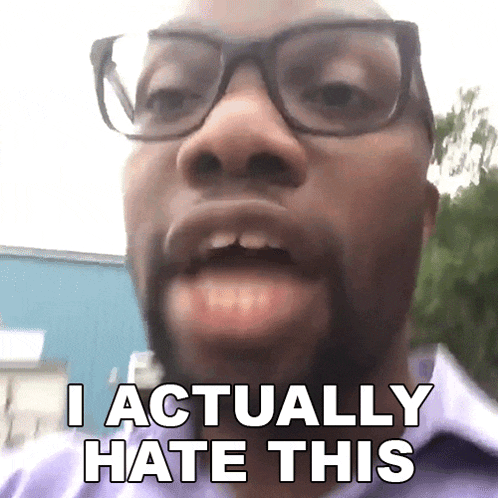 a man wearing glasses and a purple shirt says " i actually hate this "