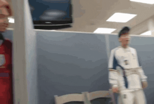 a blurry picture of a man standing in front of a tv