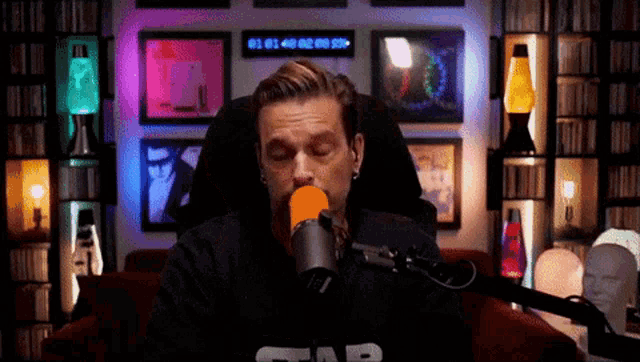 a man sitting in front of a microphone wearing a black star wars shirt