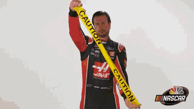 a man holding a yellow caution tape over his head
