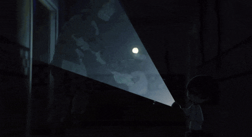 a person is standing in a dark room with a glowing circle in front of them
