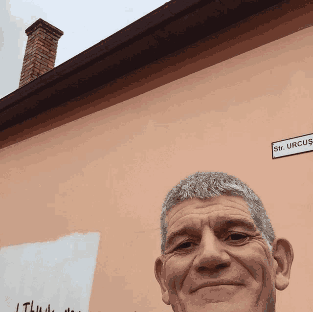 a man stands in front of a building with a sign that says str. urcus on it