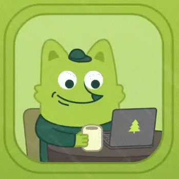 a green cartoon character is sitting at a table with a laptop and holding a cup of coffee .