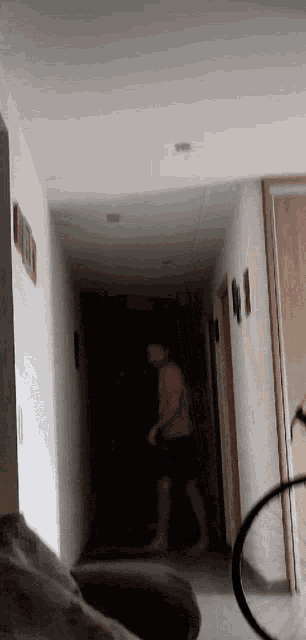 a person is walking down a hallway with a bicycle in the background