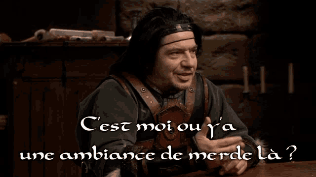a man sitting at a table with the words " cest moi ou y 'a une ambiance de merde la " on the bottom