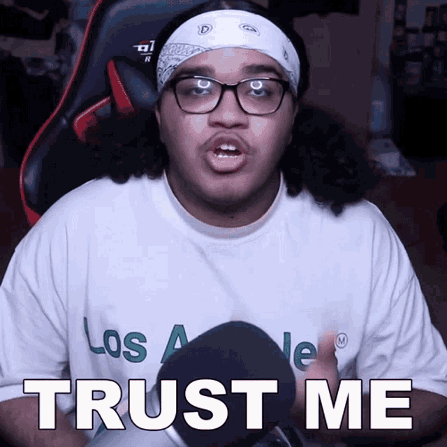 a man wearing glasses and a bandana has the words trust me on his shirt