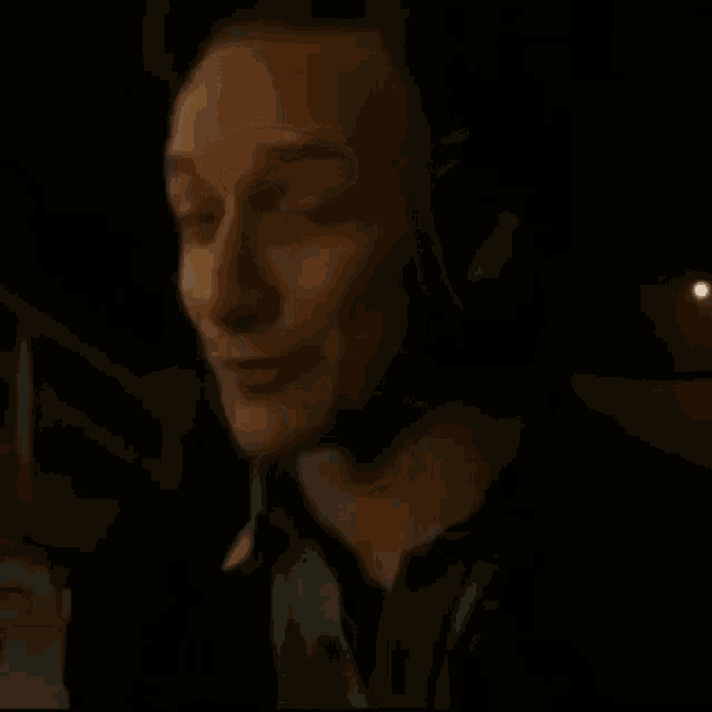 a close up of a man 's face in the dark with a serious look on his face .
