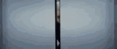 an elderly woman is standing in a doorway looking out .