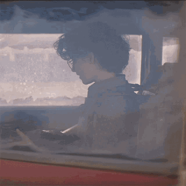 a person sitting in a car with smoke coming out the window