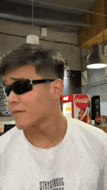 a man wearing sunglasses and a staystrong shirt
