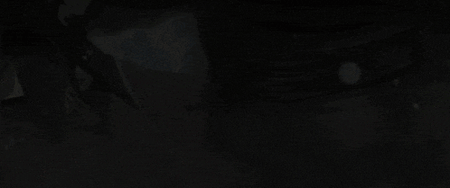 a close up of a colorful object with the letter w on it in the dark