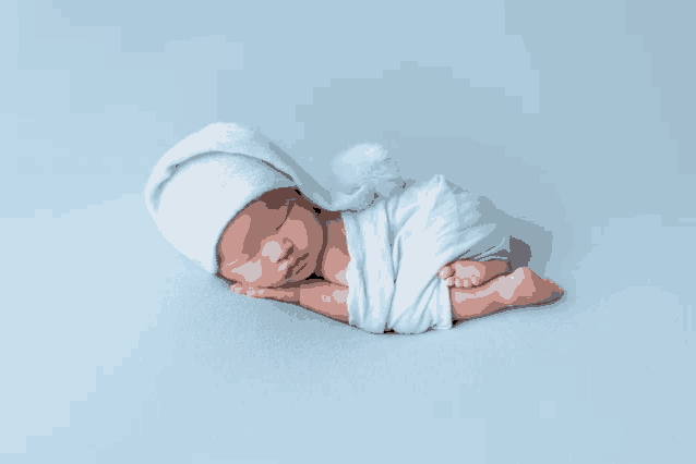 a baby wrapped in a blue blanket and wearing a hat