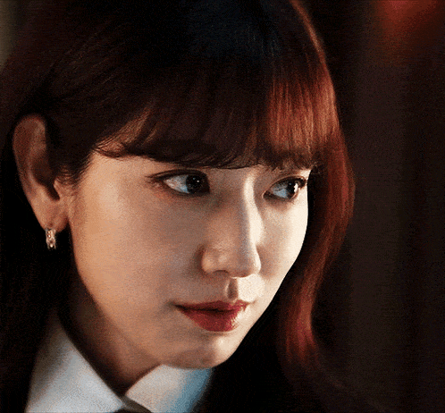 a close up of a woman 's face with a white shirt and tie