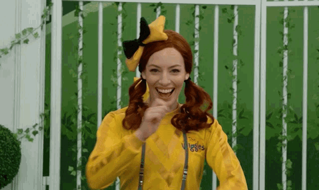 a woman with red hair is wearing a yellow wiggles shirt