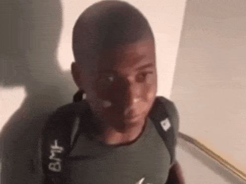 a young man with a backpack on his back is looking at the camera and making a funny face .