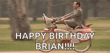 a man in a suit is riding a bicycle with his feet up in the air .