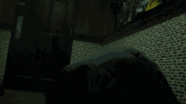 a blurred image of a person kneeling in a dark room
