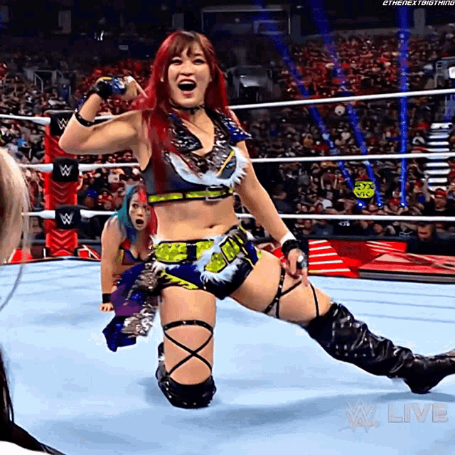 a woman in a wrestling ring with the words w live on the bottom right