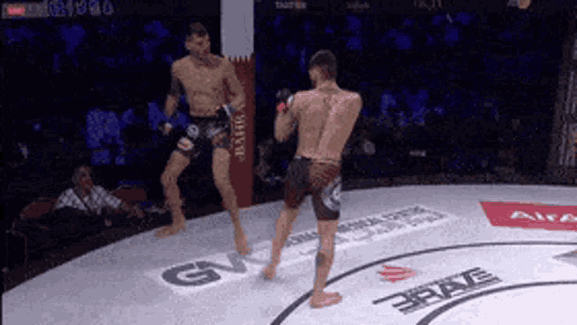 two men are fighting in a boxing ring with a sign that says gv on it .
