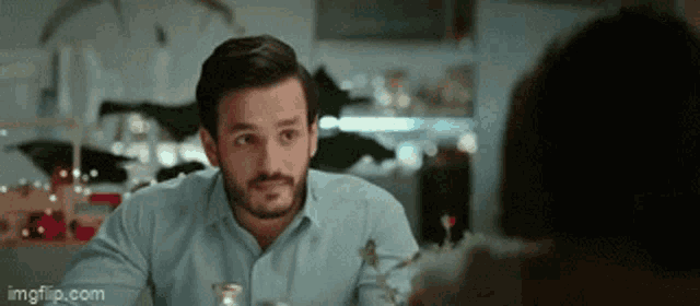 a man is sitting at a table talking to a woman .
