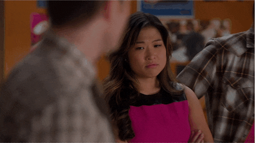 a woman in a pink and black dress making a face