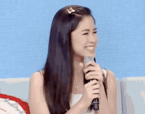 a woman is covering her mouth with her hand and laughing .