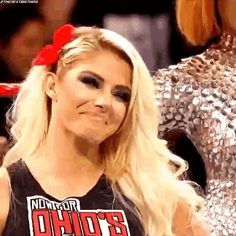 a woman with blonde hair and a red bow in her hair is making a face .