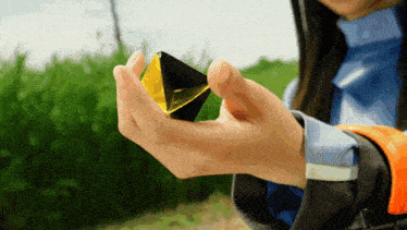 a woman is holding a yellow and black object in her hands