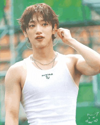 a man wearing a white tank top that says action