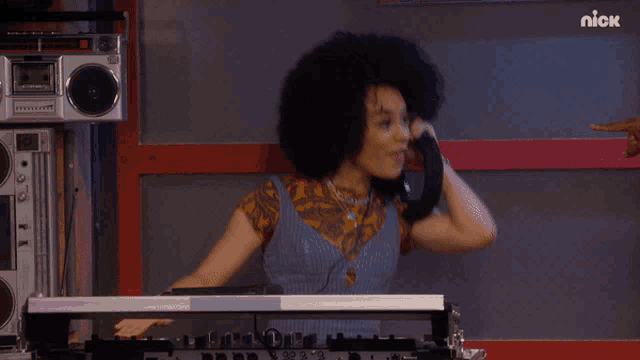 a woman wearing headphones is playing music in front of a nick logo