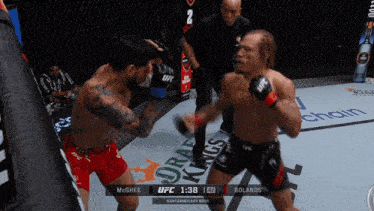 two men are fighting in a boxing ring with a ufc logo on the corner