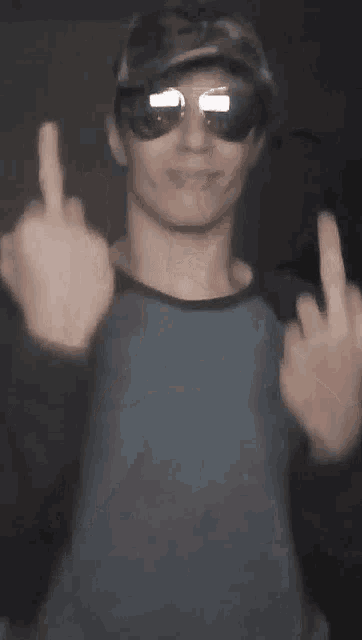 a man wearing sunglasses gives the middle finger
