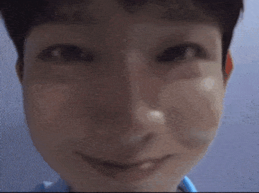 a close up of a person 's face with a smile on his face .