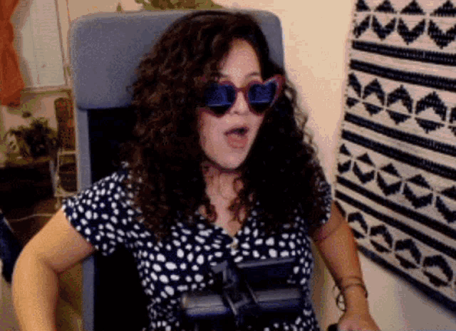 a woman wearing heart shaped sunglasses and a polka dot shirt