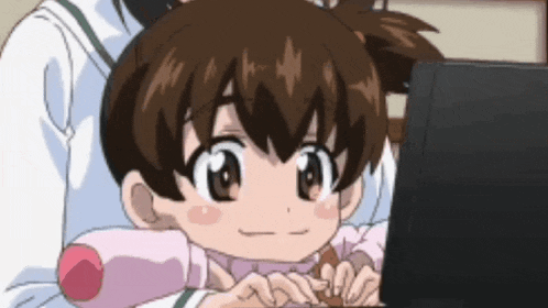 a little girl is smiling while looking at a laptop screen