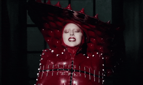 a woman in a red latex costume with spikes on her head