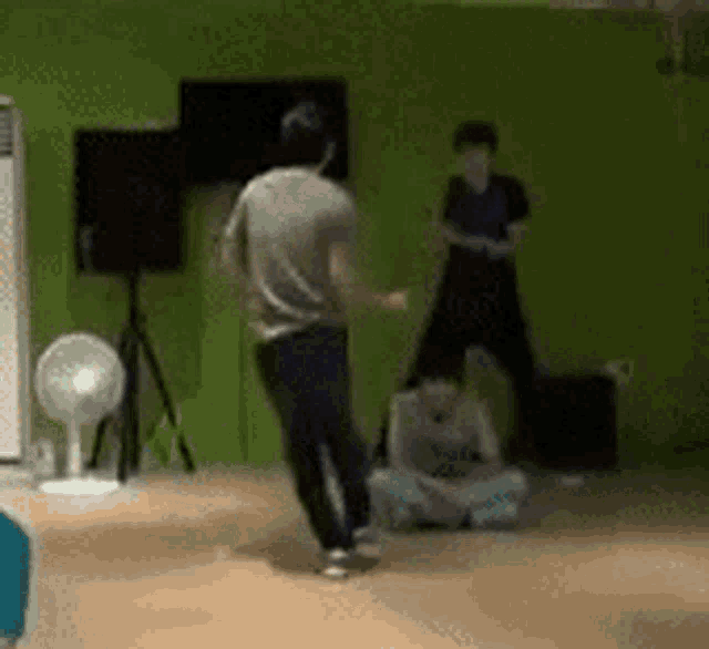 a man is dancing in a room with other people .