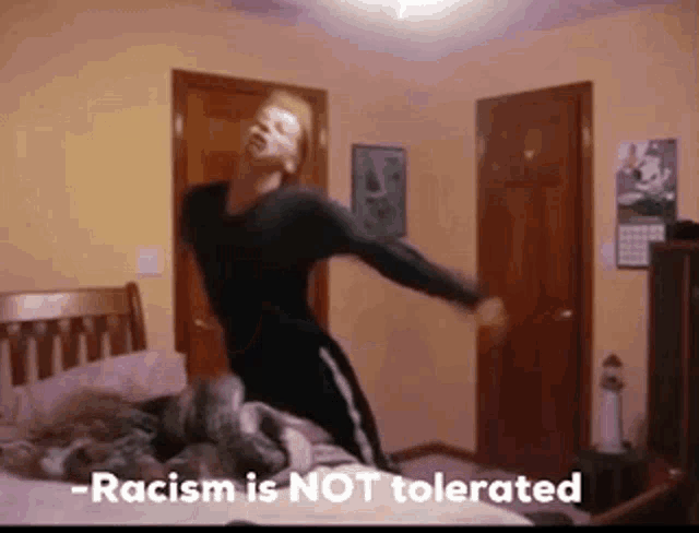 a man dancing in a bedroom with the words " racism is not tolerated " on the bottom