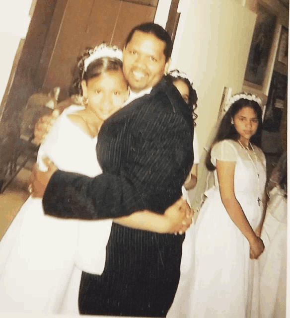 a man in a suit is holding a little girl in his arms