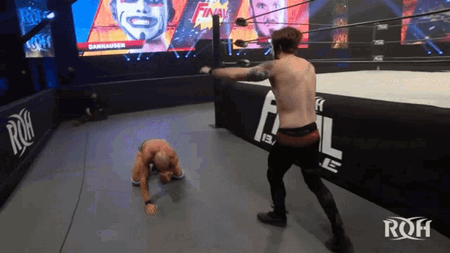a man in a wrestling ring with a sign that says roh on it