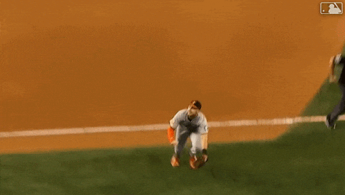 a baseball player is sliding into a base while wearing a catcher 's mitt .